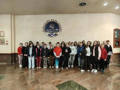 Grupa uczniów SP w Długołęce-Świerkli w holu Narodowego Banku Polskiego we Wrocławiu, pod godłem NBP