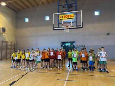 Uczestnicy gminnego turnieju koszykówki 3x3 z dyplomami w hali sportowej pod koszem